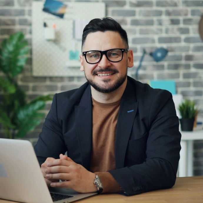 a man sitting at a table with a laptop
