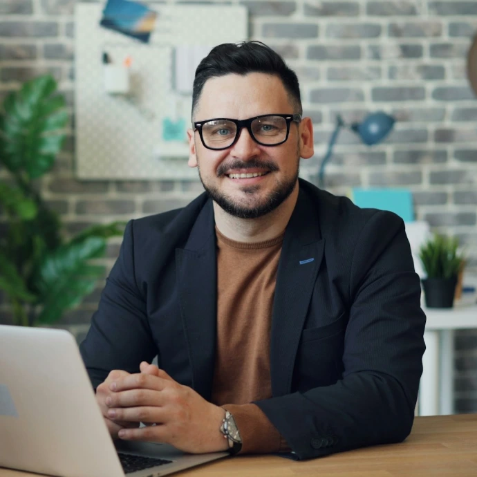 a man sitting at a table with a laptop